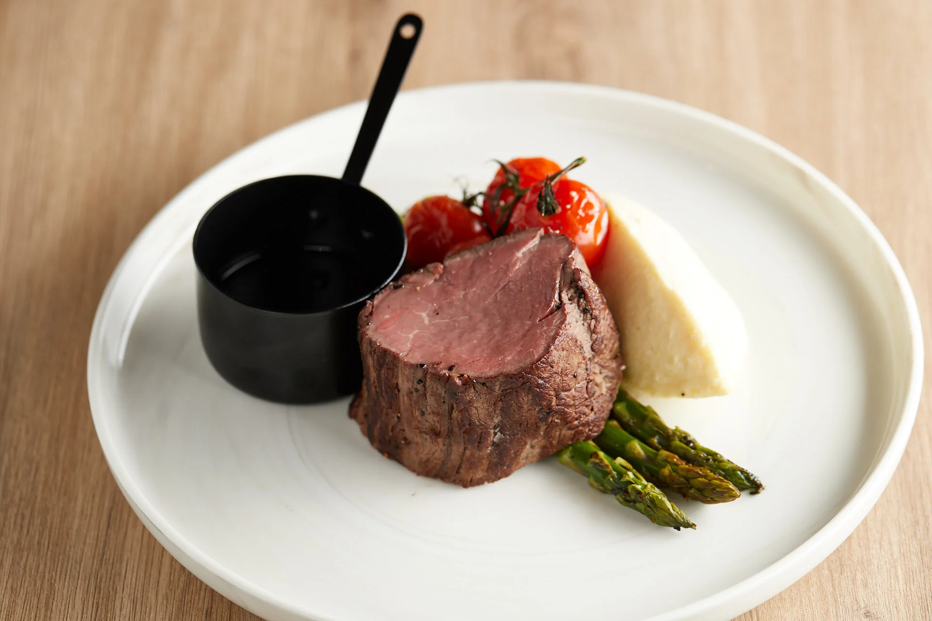 Beef fillet served with asparagus and roasted tomato